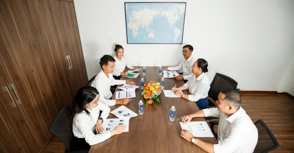 Group of professionals having a strategic business meeting at a conference table in a modern office setting.