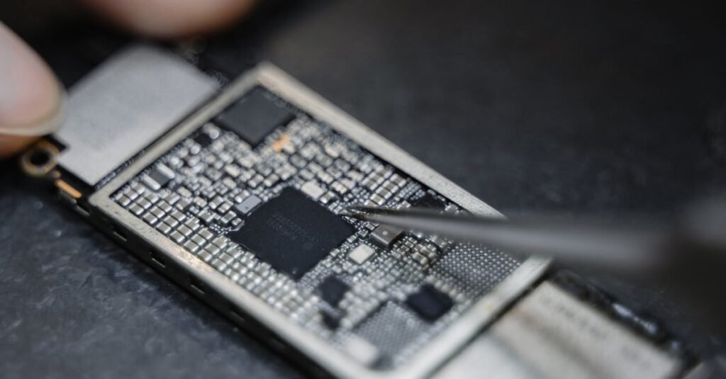 Detailed view of a technician using tweezers to fix an electronic circuit board.