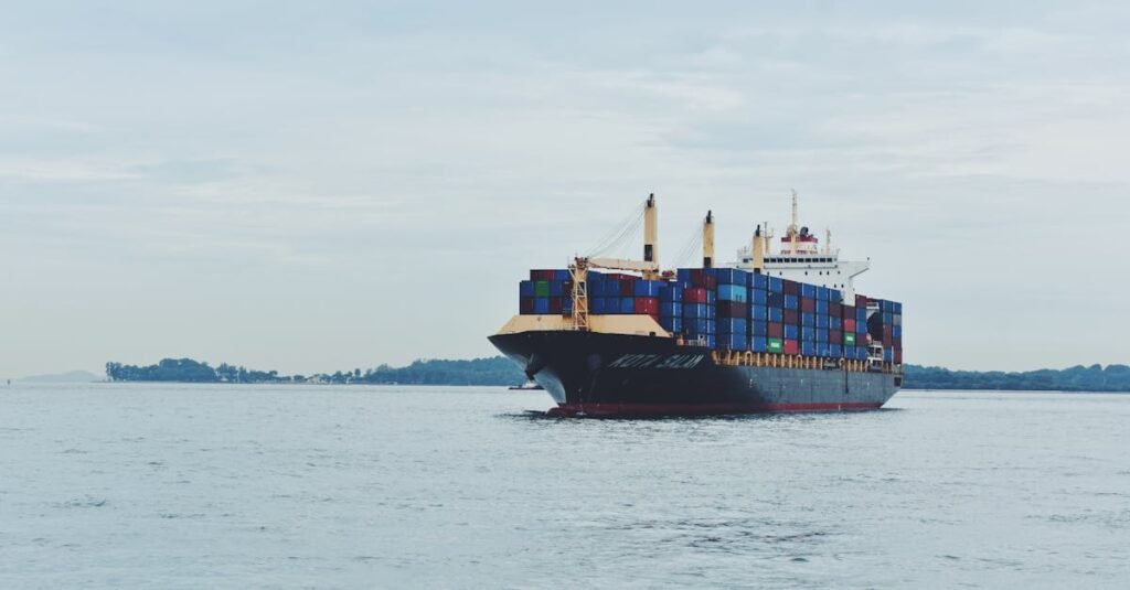 Large cargo ship transporting containers across a calm sea, symbolizing global logistics.
