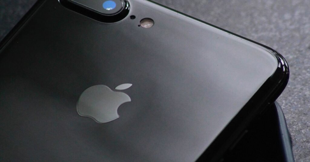 Close-up of a sleek black smartphone with dual camera lenses on a textured surface.