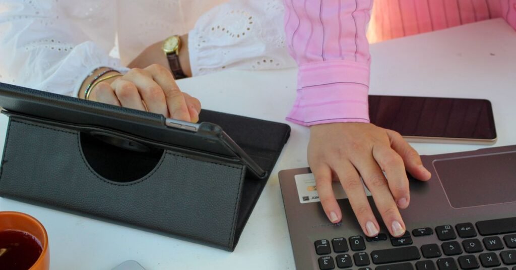 Office scene showing teamwork using a laptop, tablet, and smartphone.