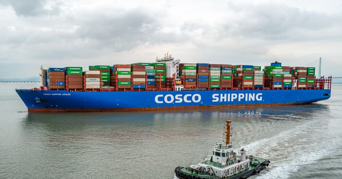 A large COSCO container ship navigates the waters of Ningbo Harbor, China.