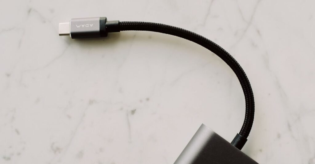 A close-up view of a black USB-C cable with a braided cord resting on a light marble surface.