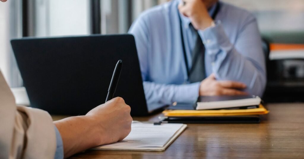 Crop anonymous female filling questionnaire when applying for job sitting in employer office