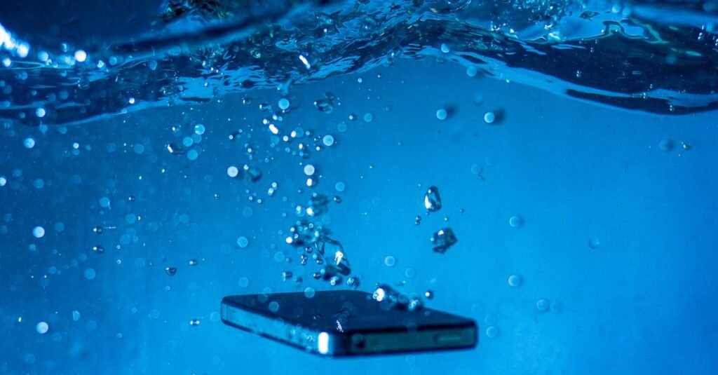 A smartphone submerged in water with bubbles rising around it, showcasing a dynamic underwater scene.
