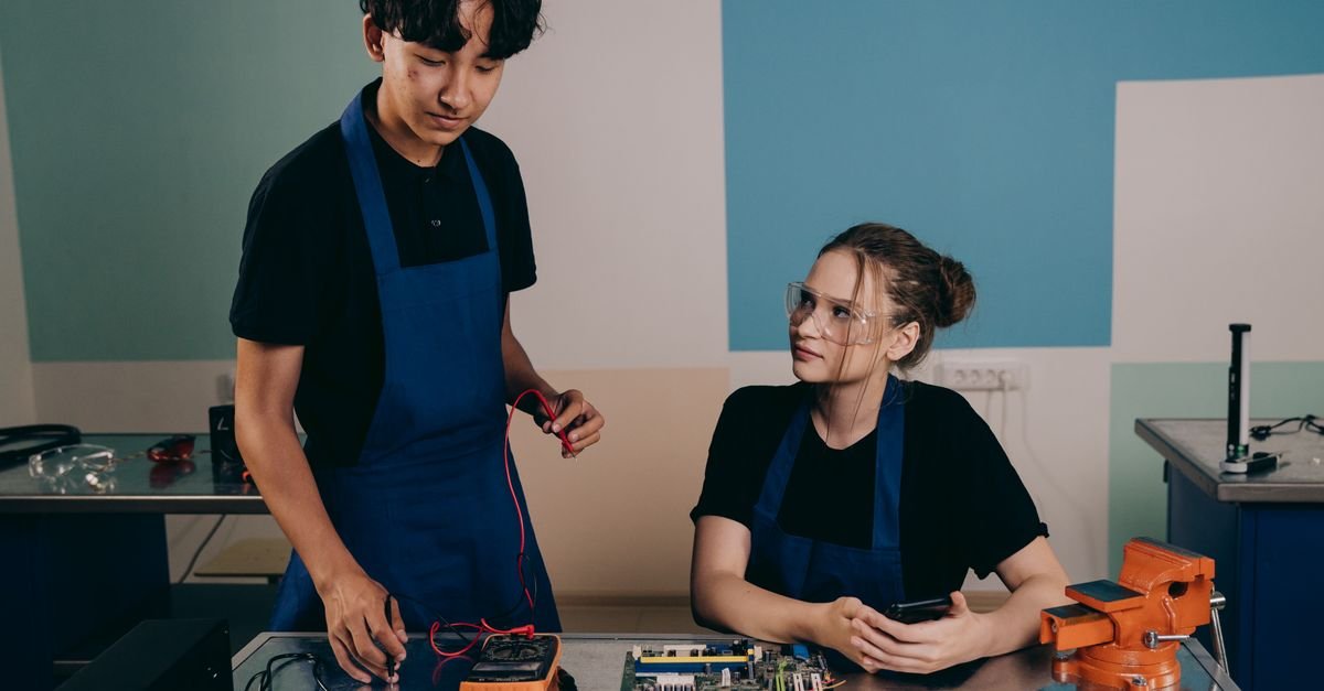 Two technicians working together on electronics, emphasizing teamwork and innovation.